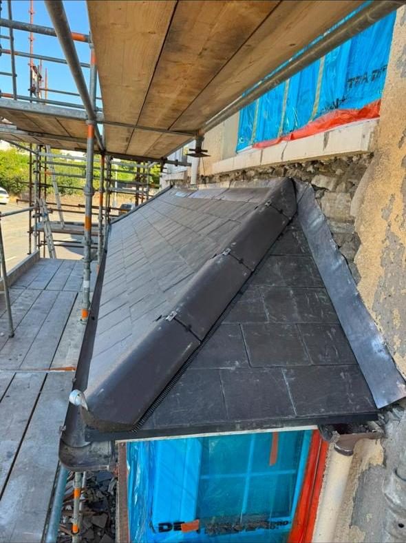 Hip roof slating with lead capping on scaffold