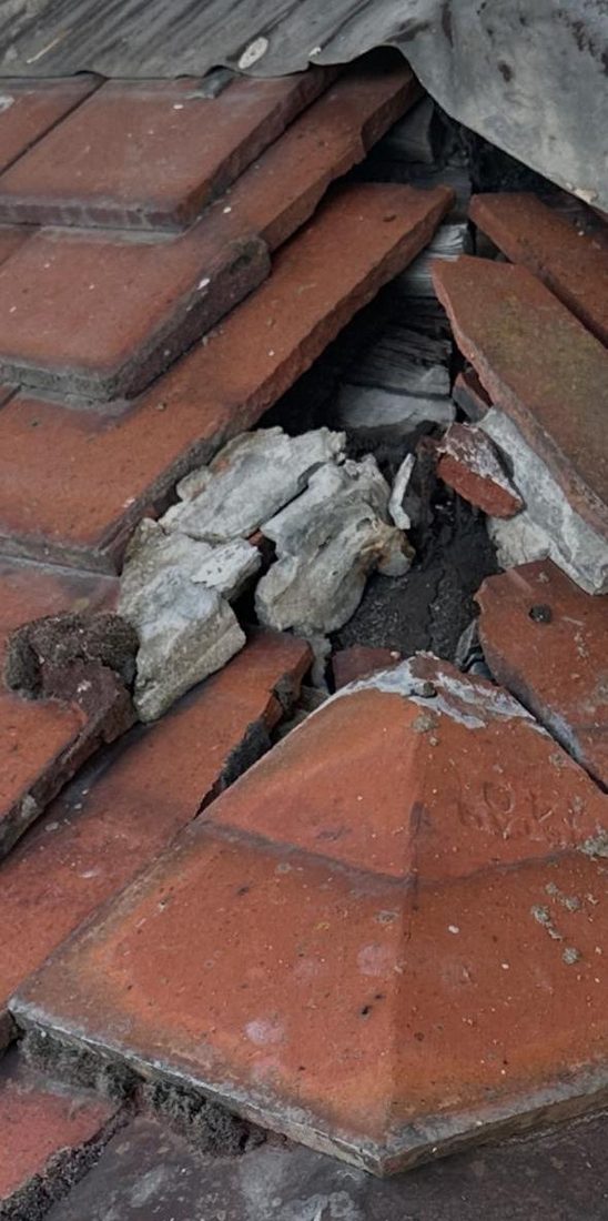 Cracked and displaced roof tiles before repair