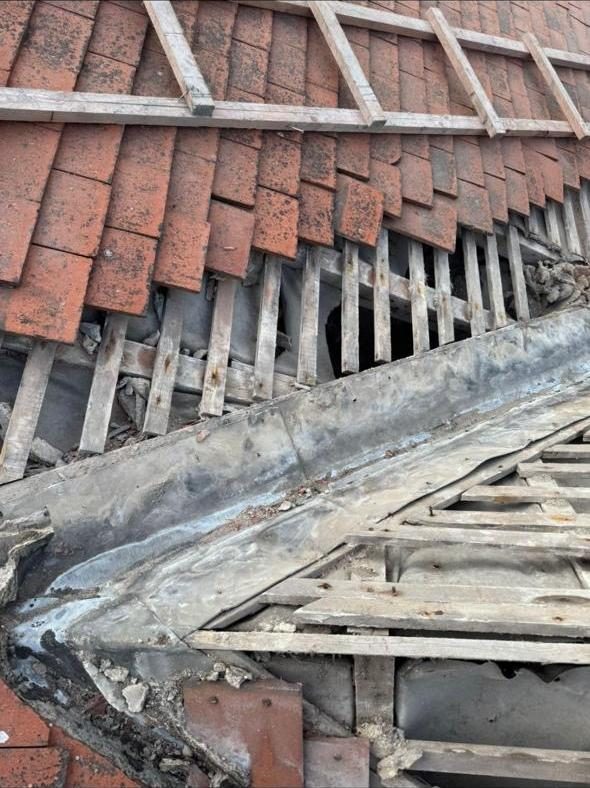 Old lead valley and rotten timbers exposed during strip-out