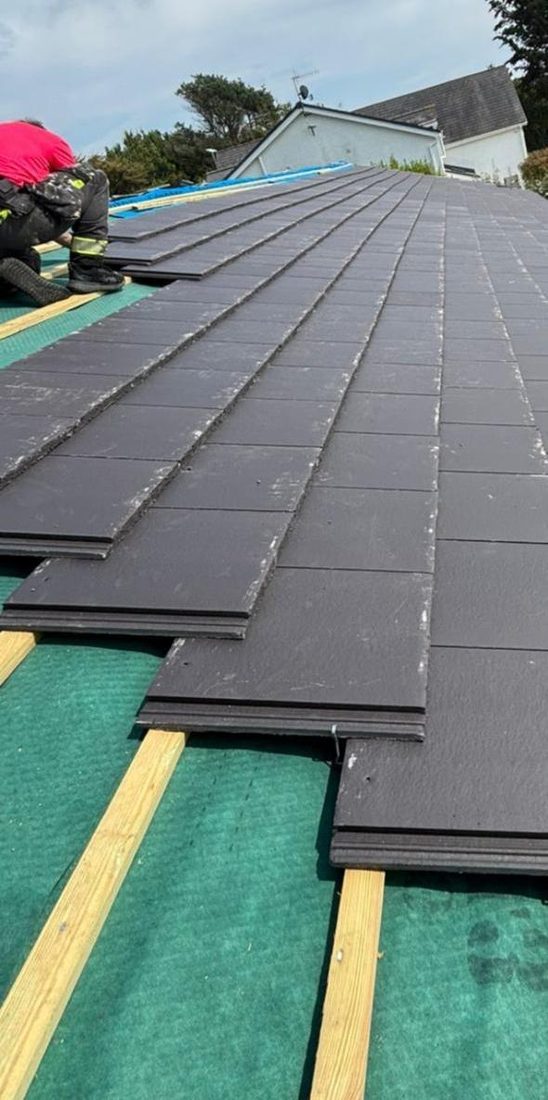 New composite roof tiles being fitted