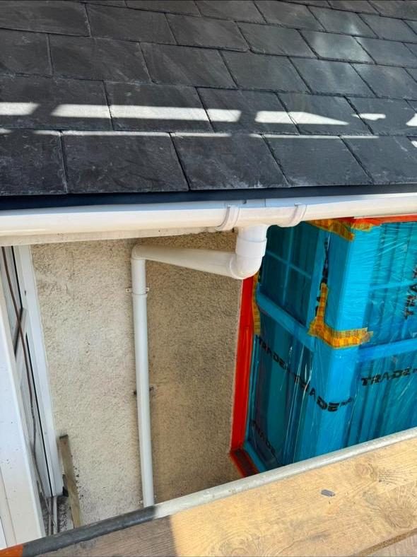 New guttering and downpipe fitted beneath slate roof